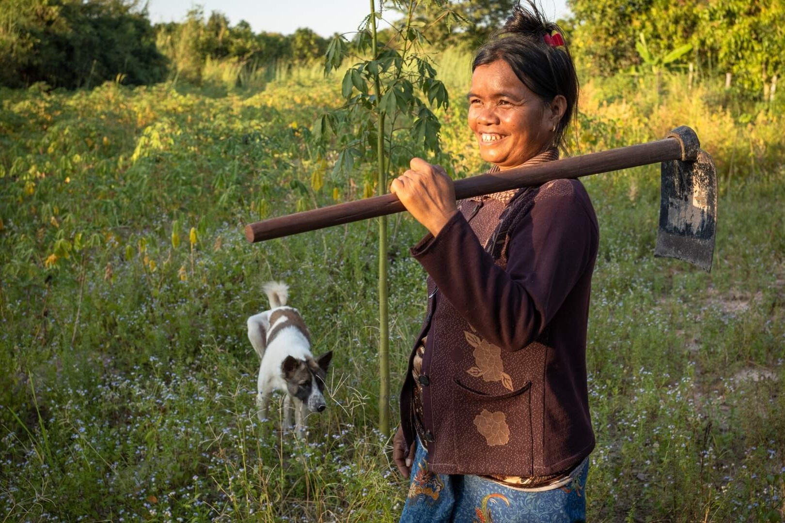 woman walks with farming equipment