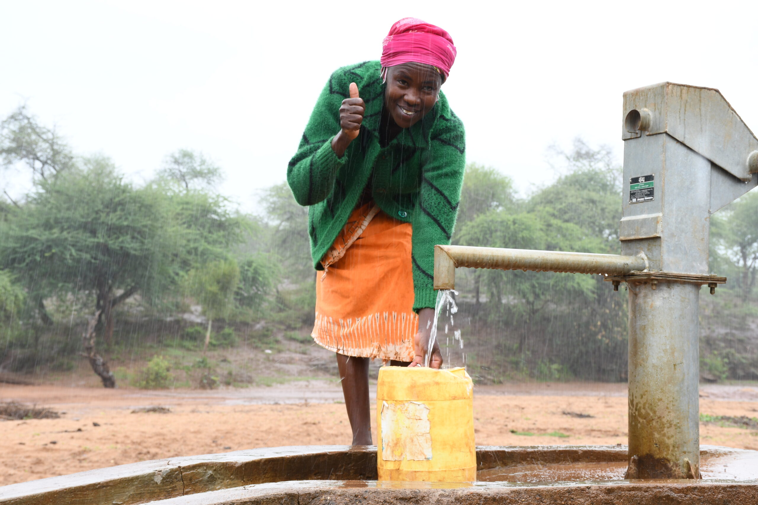 woman smiles while filling up jerrycan
