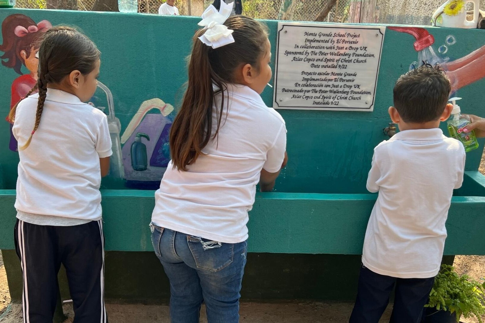 school children wash hands at handwashing station