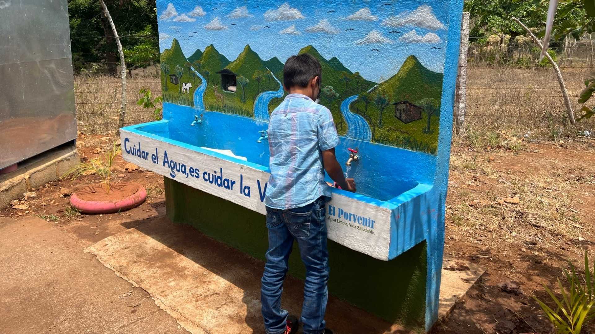 boy washes hands at handwashing station