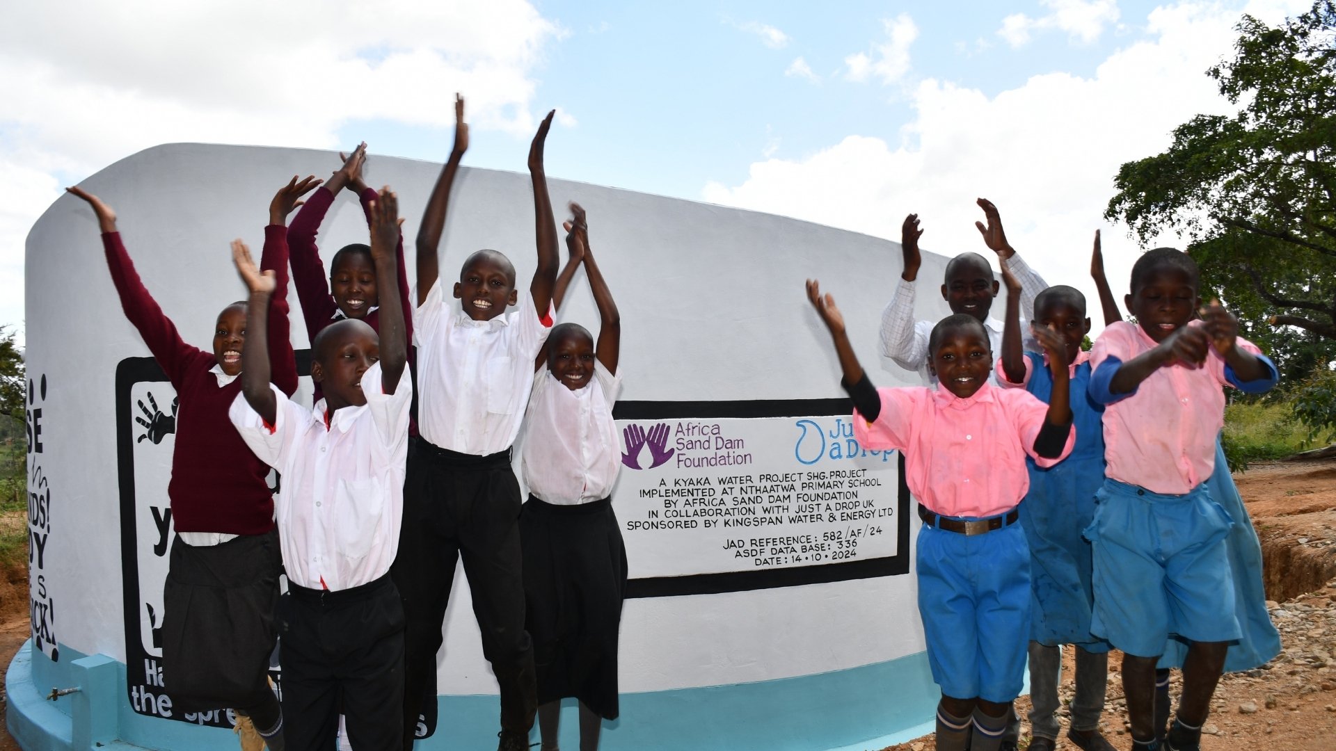 school children with rainwater harvesting tank