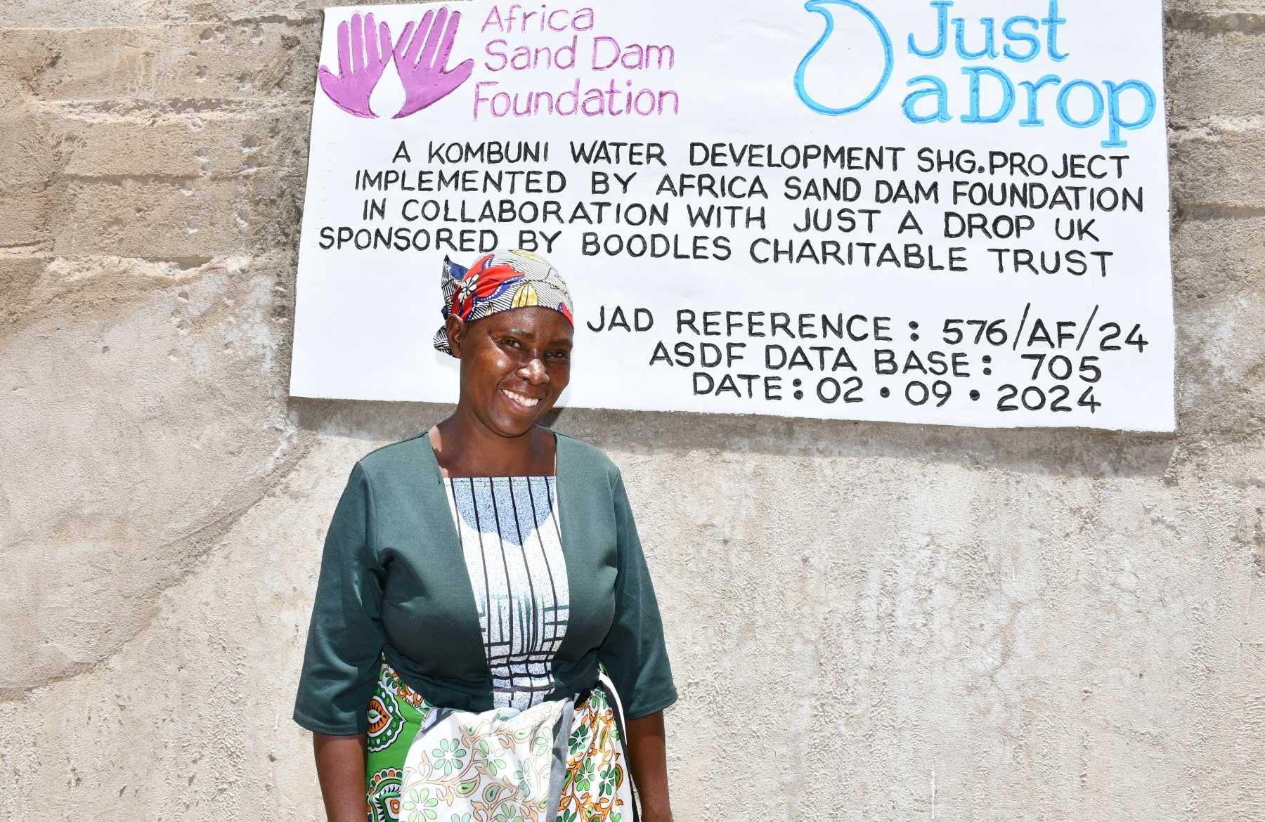 woman by sand dam plaque
