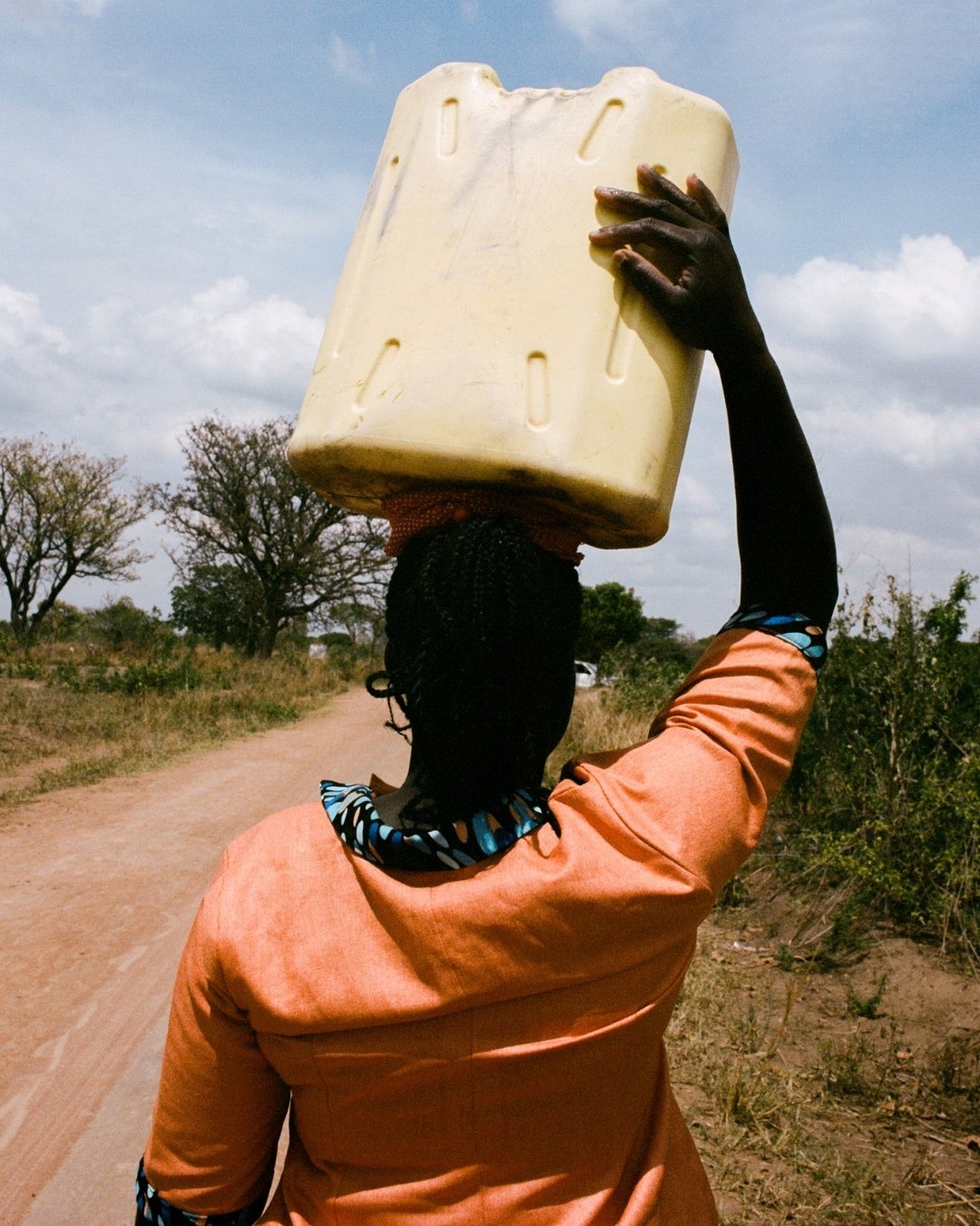 woman carries jerrycan