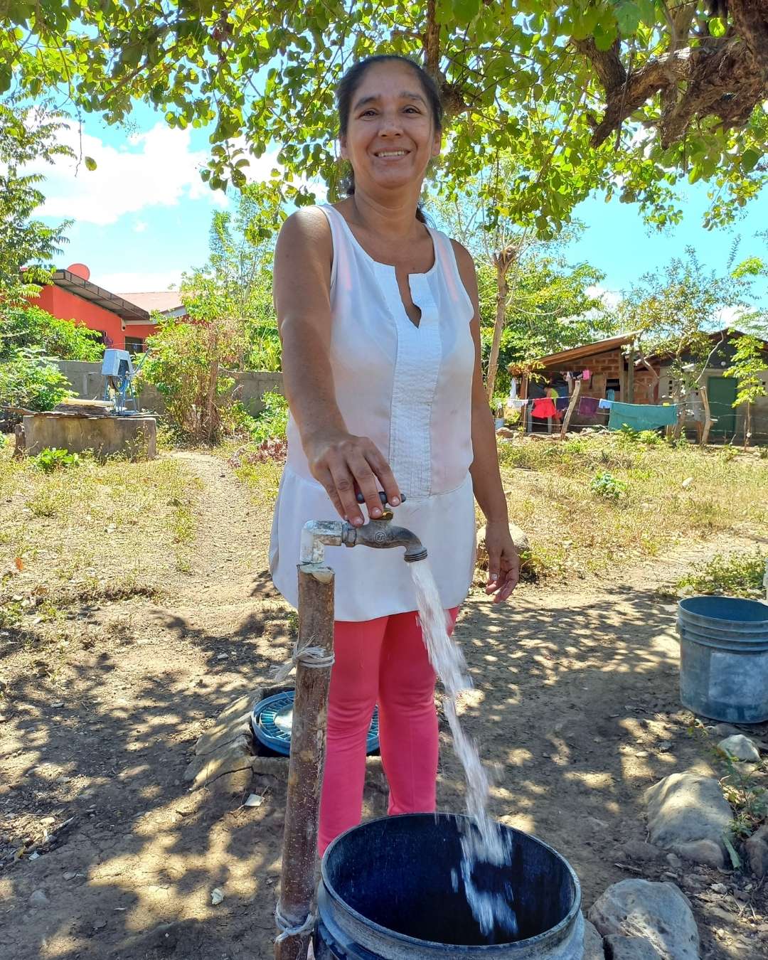 woman filling up bucket from safe water tap