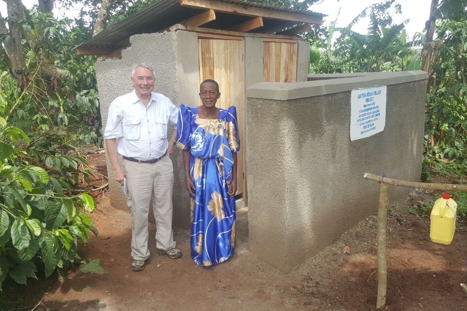 mike with a community member beside latrine