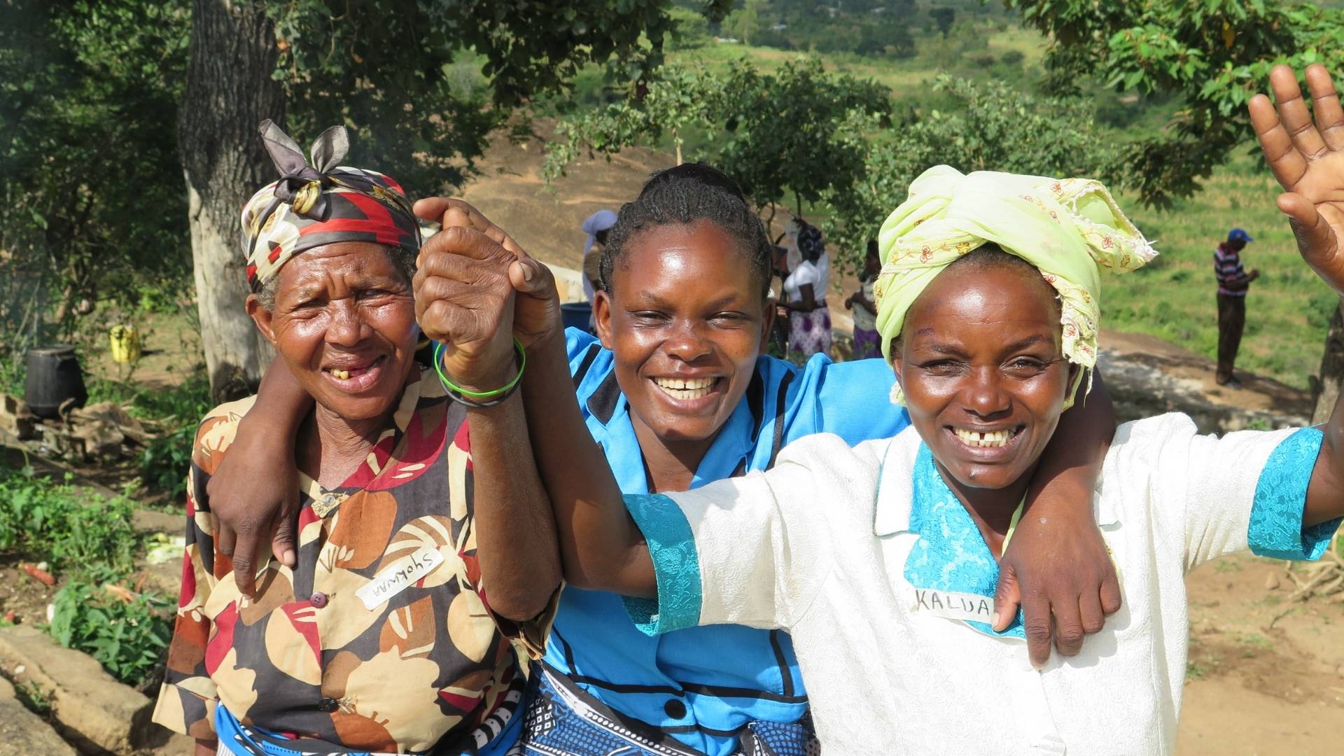 three women wave to camera